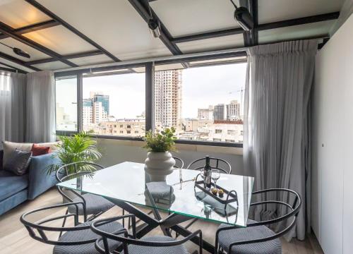 a glass table and chairs in a room with a window at JLM Rooftop luxury apartment in Jerusalem