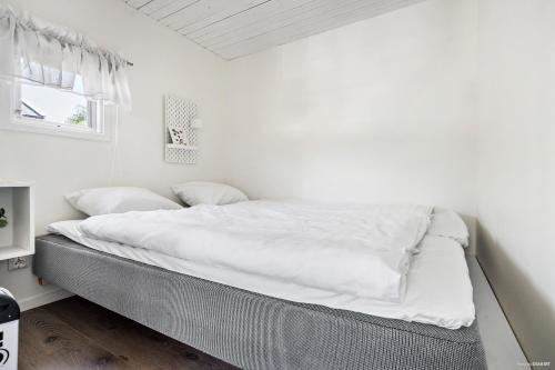 a bed in a room with white walls and a window at First Camp Nickstabadet-Nynäshamn in Nynäshamn