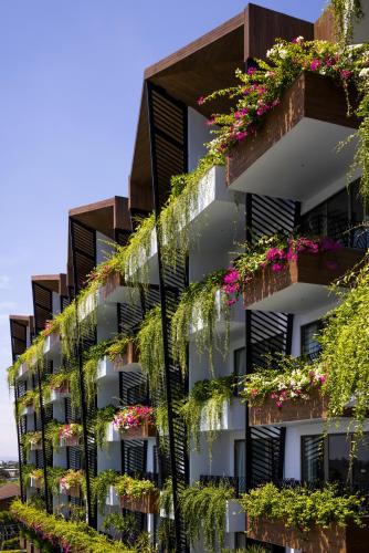 an apartment building with flowers on the balconies at Bellerive Hoi An Resort and Spa in Hoi An