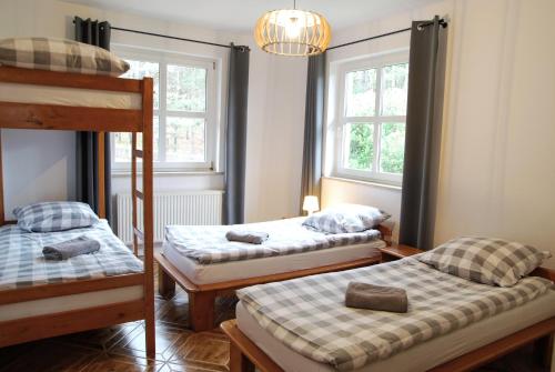 a room with two bunk beds and two windows at Ośrodek wypoczynkowy Jezioro in Studzienice
