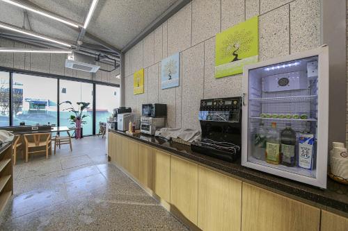 a restaurant with a counter with an open refrigerator at GwangJu Gwangsangu Hanam HoundHotel in Gwangju