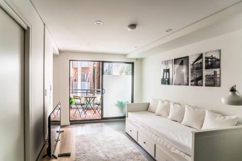 a living room with a white couch and a window at CBD#UnitB Greenland3 Darling Harbour in Sydney