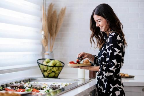 a woman standing in a kitchen preparing food at Irida Hotel Agia Pelagia in Agia Pelagia
