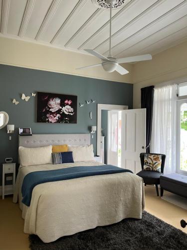 a bedroom with a large bed and a ceiling fan at Chelsea House Bed & Breakfast in Whangarei