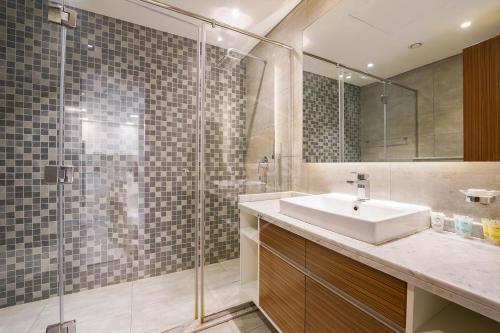 a bathroom with a sink and a shower at KeyHost - Regent Court JVC - K420 in Dubai