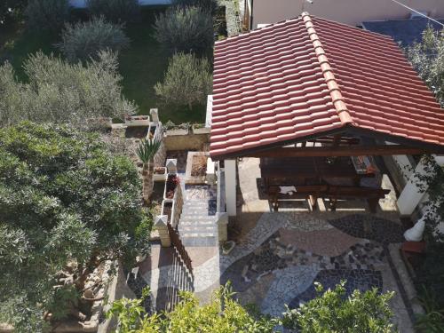 a house with a table and a roof at Apartment in Lopar with sea view, terrace, washing machine 593-4 in Lopar