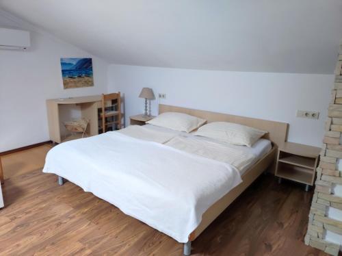 a bedroom with a white bed and a brick wall at Apartment in Lopar with sea view, terrace, air conditioning, washing machine 593-3 in Lopar