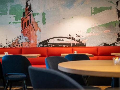 a restaurant with tables and chairs and a mural at Good Morning Jönköping in Jönköping