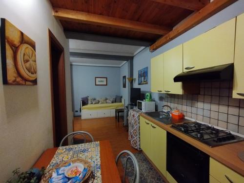 uma cozinha com uma mesa e um fogão forno superior em Apartment Trezza em Acitrezza