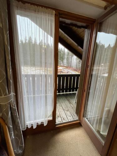 a room with a window with curtains and a balcony at FitApartman in Mitterfirmiansreut