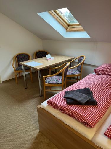 a room with a table and chairs and a bed at FitApartman in Mitterfirmiansreut