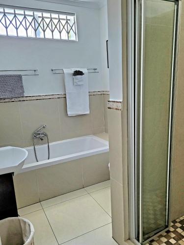 a bathroom with a bath tub and a sink at B&B on Buckingham Guest House in Johannesburg