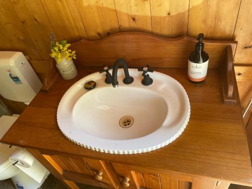 a sink in a bathroom with a bottle of wine at Rustic miners cabin in Faraday