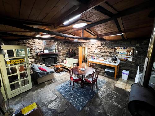 sala de estar con mesa y pared de piedra en Rustic miners cabin en Faraday