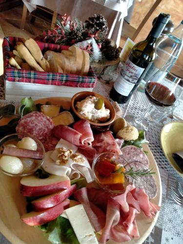 a table with a plate of food and a bottle of wine at Agriturismo L'Antico Sapore in Baraggia di Boca