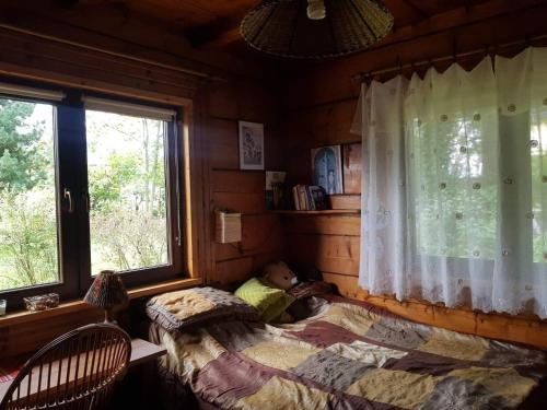 1 dormitorio con 1 cama en una cabaña de madera en Stara chałupa, en Murzasichle