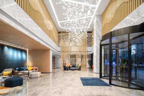 a lobby with couches and a chandelier in a building at Holiday Inn Express Nanchang Riverside by IHG in Nanchang