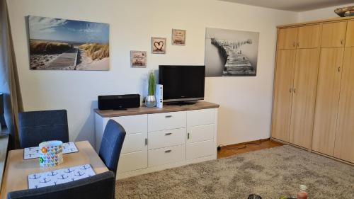 a living room with a table and a tv on a cabinet at PEMATRA Ferienwohnung Seeschwalbe in Travemünde