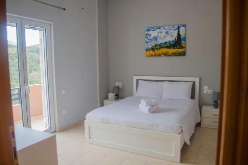 a bedroom with a white bed with a teddy bear on it at Villa Zenovia in Heraklio
