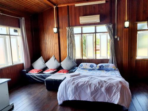 ein Schlafzimmer mit einem Bett, einem Sofa und Fenstern in der Unterkunft Homestay Kuala Terengganu One Stop 1 in Kuala Terengganu