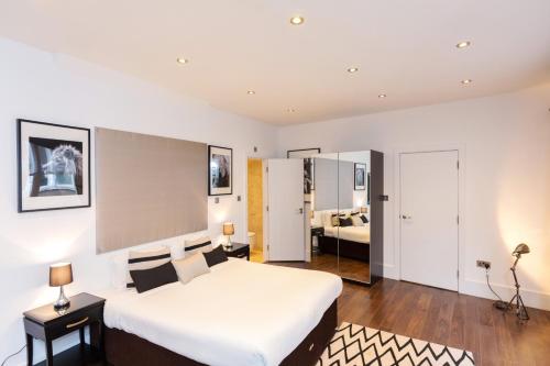 a bedroom with a large white bed in a room at Clockwork London Flats in London