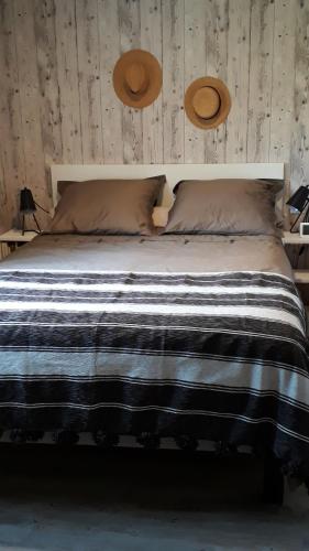 un lit avec deux chapeaux au-dessus dans l'établissement maison 2 ou 4 personnes jardin parking LES AMANDIERS, à Lorgues