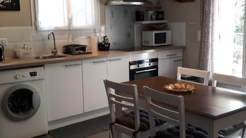 une cuisine avec une table, un évier et une cuisinière dans l'établissement maison 2 ou 4 personnes jardin parking LES AMANDIERS, à Lorgues