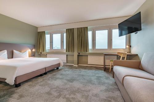 una camera d'albergo con letto e divano di flexymotel Wil a Wil
