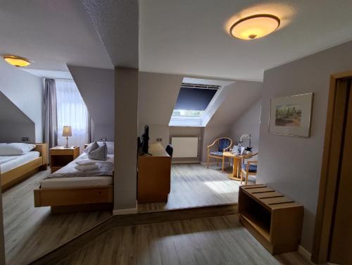 a bedroom with a bed and a desk in a room at Hotel Zum Märchenwald in Lingen