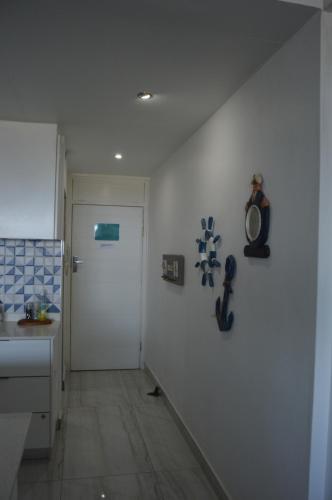 a kitchen with a white wall with a guitar magnet at Accommodation Front - Luxurious 2 Sleeper Overlooking the Beachfront in Durban