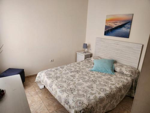 a bedroom with a bed with a blue pillow on it at Apartamento Zona Rural in Güimar