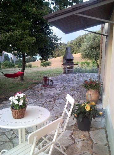 a patio with a table and chairs and a grill at Armonia della Sera B&B and Relax in Porto SantʼElpidio