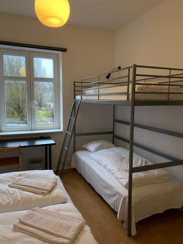 OnlySleep Femern في Holeby: سريرين بطابقين في غرفة مع نافذة