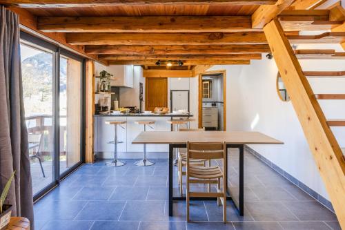 une cuisine et une salle à manger avec une table et des chaises dans l'établissement Escondido - calme et chaleureux, à Saint-Martin-de-Queyrières