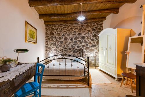 a bedroom with a bed and a stone wall at Antica dimora in Paulilatino