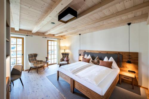 a bedroom with a large bed and a wooden ceiling at Hotel Grünerhof in Obergurgl