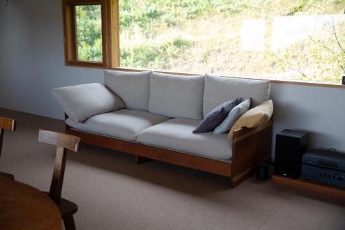 a couch sitting in a room with a window at WORM in Awaji