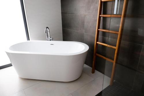 a white bath tub in a bathroom with a shelf at Canne Mapou1 in Saint-Pierre