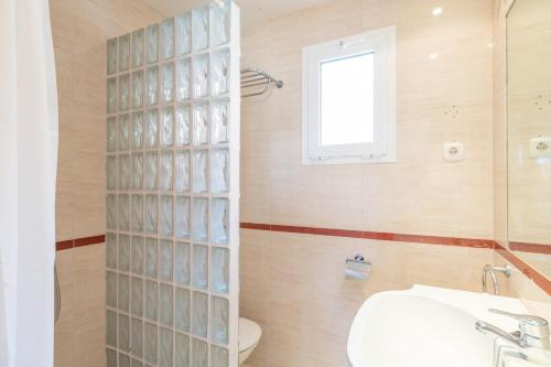 a bathroom with a toilet and a sink and a window at Renthas Añoreta Golf Beach in Torre de Benagalbón