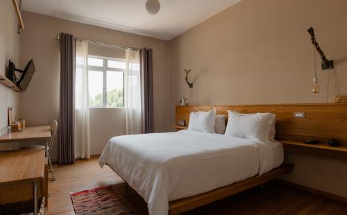 ein Schlafzimmer mit einem großen weißen Bett und einem Fenster in der Unterkunft Casa Lomah Hotel in Mexiko-Stadt