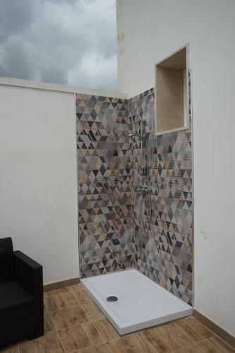 a bathroom with a shower with a tile wall at Dear Mary, B&B romantico vicino Lecce nel cuore del Salento in San Cesario di Lecce