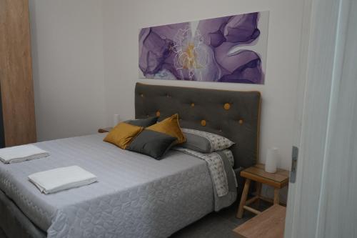 1 dormitorio con 1 cama y una pintura en la pared en Dear Mary B&B, en San Cesario di Lecce