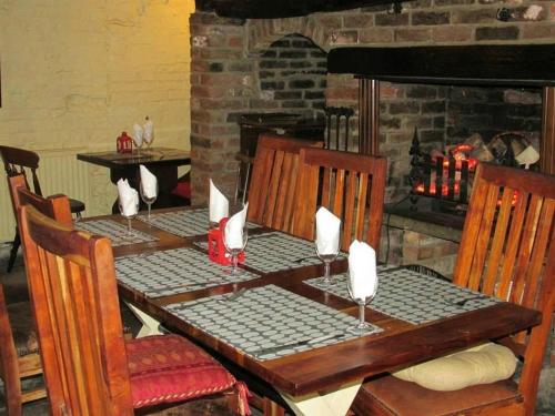 a wooden table with chairs and a table with a fireplace at Red Lion Coaching Inn in Epworth