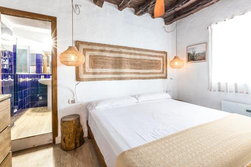 una camera con un letto bianco e una finestra di Can Toni Blay a Es Caló de Sant Agustí