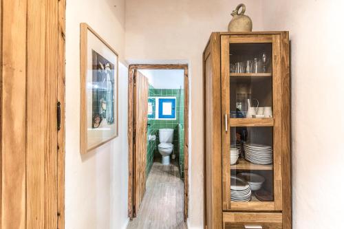 a bathroom with a mirror and a cabinet with plates at Can Toni Blay in Es Caló