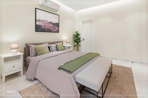um quarto com uma cama grande e um cobertor verde em A7 Luxury Apartment شقة ثلاث غرف نوم-دخول ذكي em Riyadh