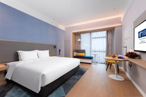 a hotel room with a large bed and a tv at Holiday Inn Express Nanchang Riverside by IHG in Nanchang