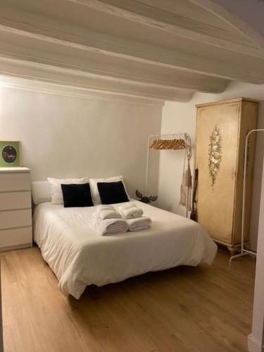 a bedroom with a large bed with white sheets at Apto. centro histórico Huesca in Huesca