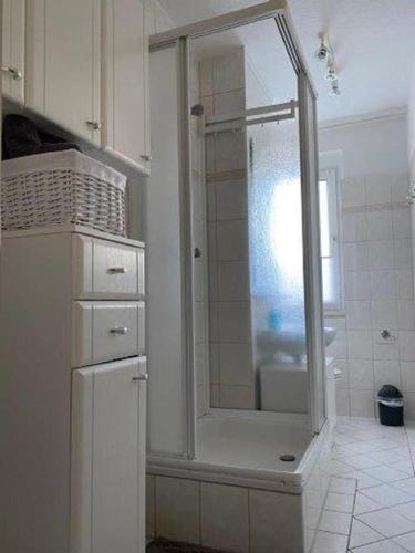 a white bathroom with a shower with a mirror at Gästewohnung KL. WZL 40_4 
