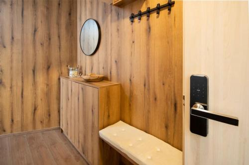 a bathroom with a mirror and a wooden wall at Apartmán Na vŕšku in Dolný Kubín